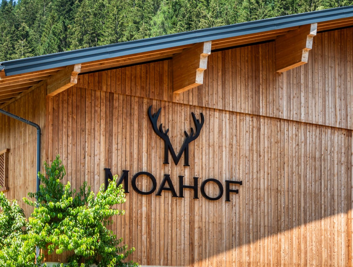 Außenfassade aus Holz am Moahof in Werfenweng mit Logo-Beschriftung.